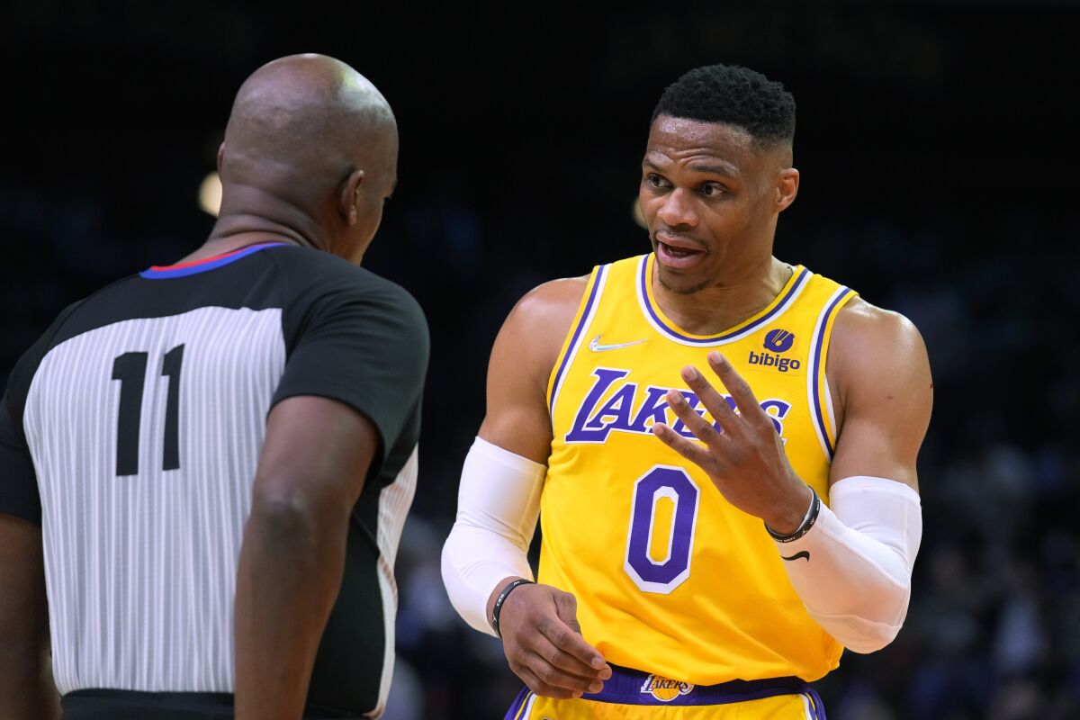 Los Angeles Lakers guard Russell Westbrook (0) talks to referee Derrick Collins (11) during the second half of the team's NBA basketball game against the Phoenix Suns, Tuesday, April 5, 2022, in Phoenix. The Suns won 121-110. (AP Photo/Rick Scuteri)