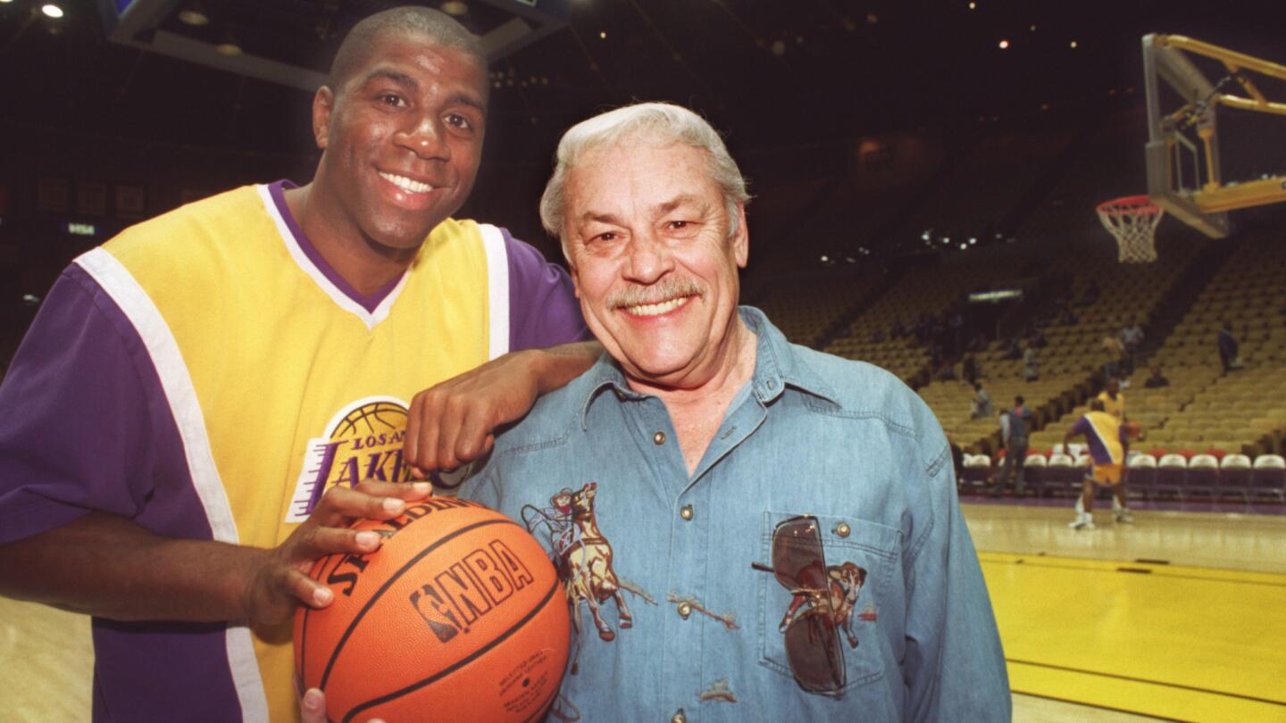 Lakers star Magic Johnson, left, poses for a photo with team owner Jerry Buss at the Forum in April 1996.