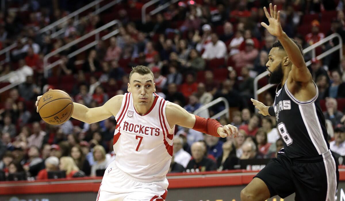 Houston Rockets' Sam Dekker (7) drives toward the basket as San Antonio Spurs' Patty Mills (8) defends during the first half on Tuesday.