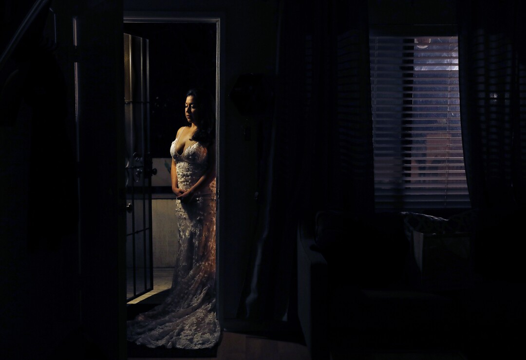 Martha Suarez Ballesteros wears her wedding dress at home in Fullerton.
