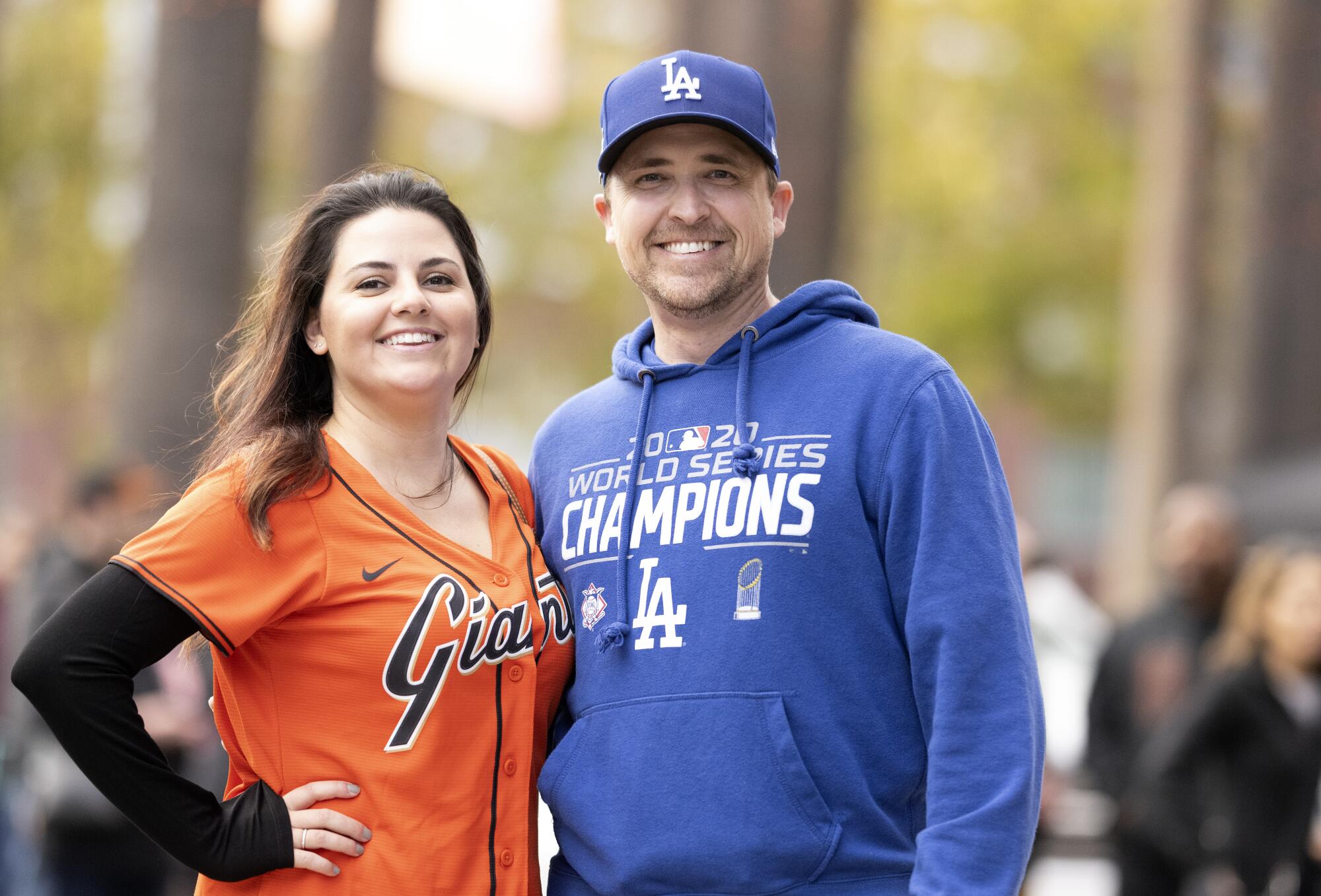 Johnathan Bryant in a Dodgers hoodie stands with his wife, Desiree, who is in a Giants shirt.