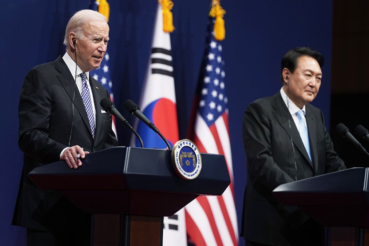 President Biden and South Korean President Yoon Seok-youl stand at lecterns with flags behind them.
