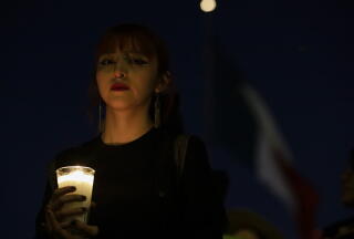 A young woman holds a candle.