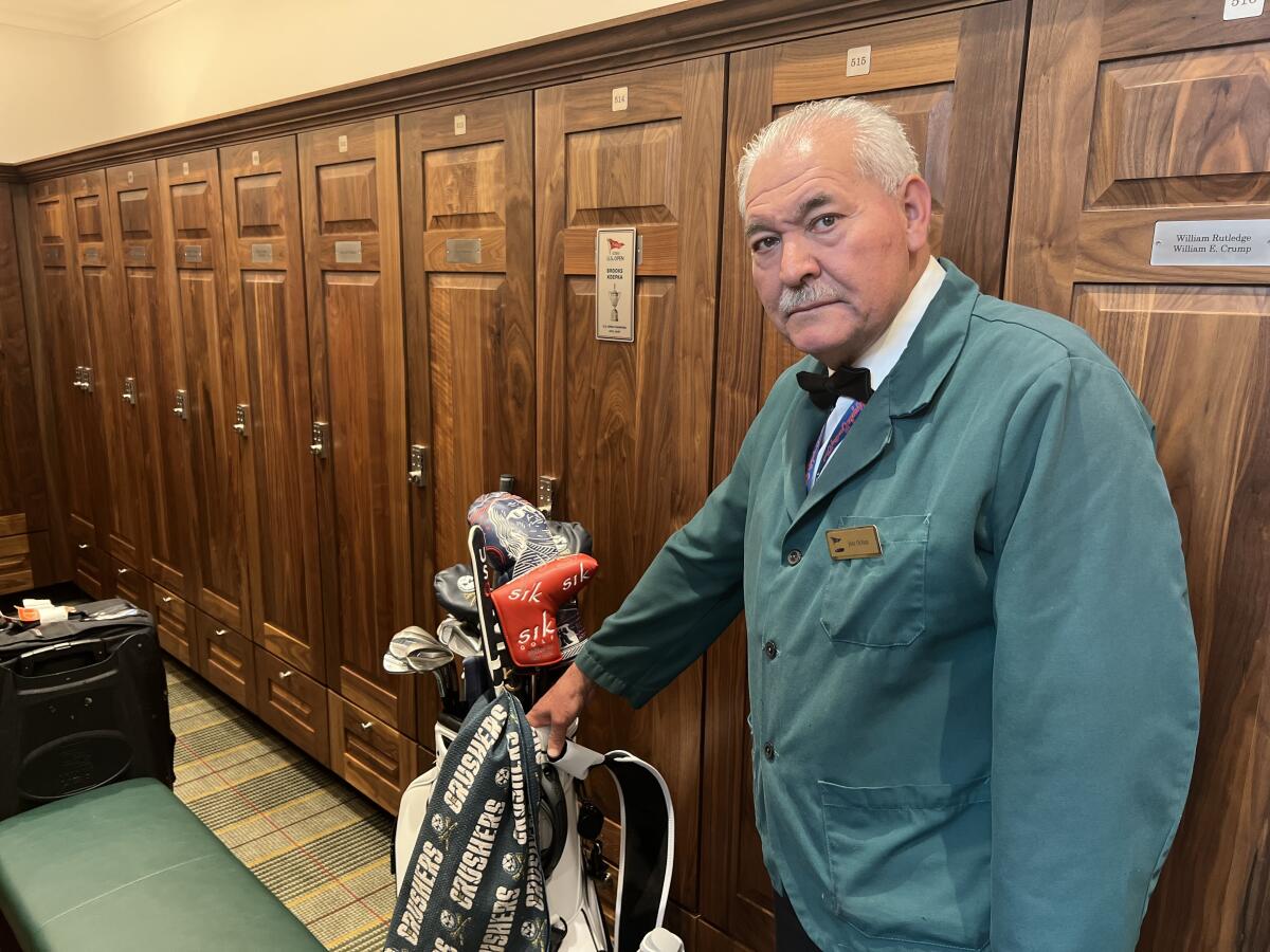 Jose Ochoa poses with clubs in locker room of the L.A. Country Club. He is the head locker room attendant.