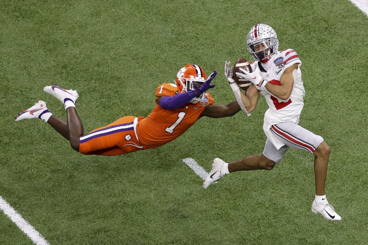 Ohio State receiver Chris Olave catches a touchdown pass despite coverage by Clemson's Derion Kendrick in the Sugar Bowl.