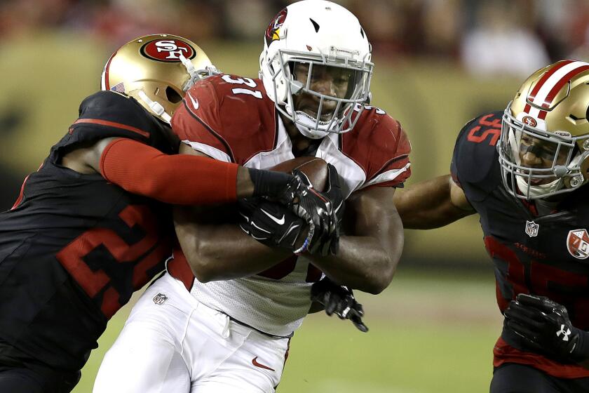 Cardinals running back David Johnson, getting tackled by 49ers safeties Jaquiski Tartt (29) and Eric Reid (35), rushed for 157 yards in the game.