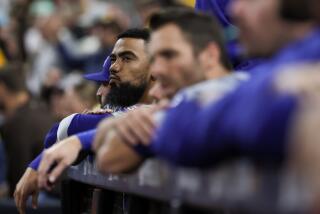 Teoscar Hernández watches from the dugout alongside his Dodgers teammates against the Padres at Petco Park.