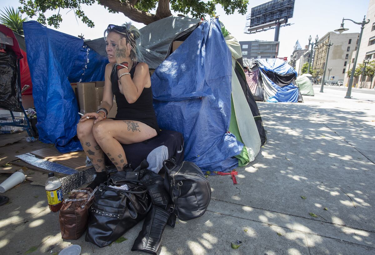 Tasha Tinsley, 41, sits next to a friend's tent at an encampment near 3rd and Main streets in downtown Los Angeles.