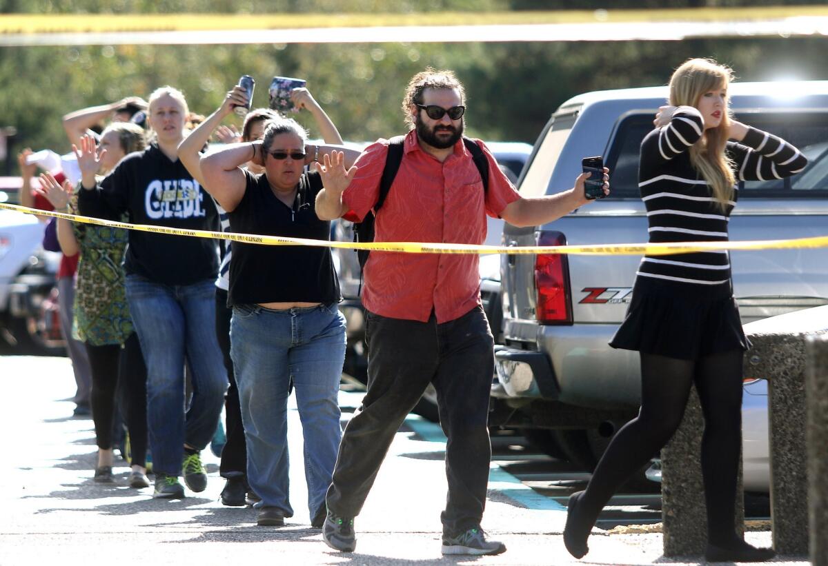 Students, staff and faculty are evacuated from Umpqua Community College in Roseburg, Ore., after a deadly shooting Thursday, Oct. 1, 2015.