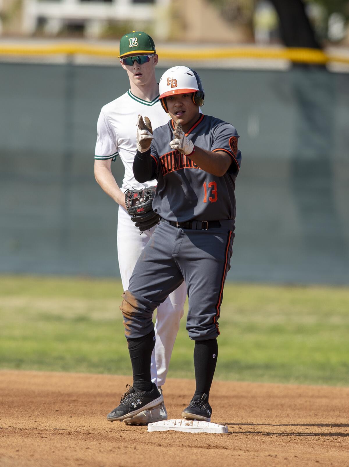 Huntington Beach's Tony Martinez gestures to the bench after hitting a double against Edison during