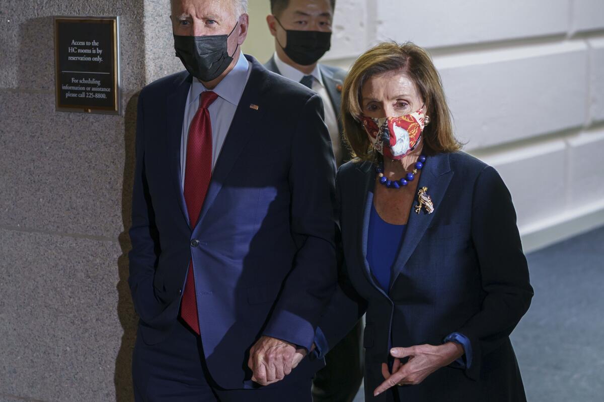 President Biden and Speaker of the House Nancy Pelosi walk through a hallway