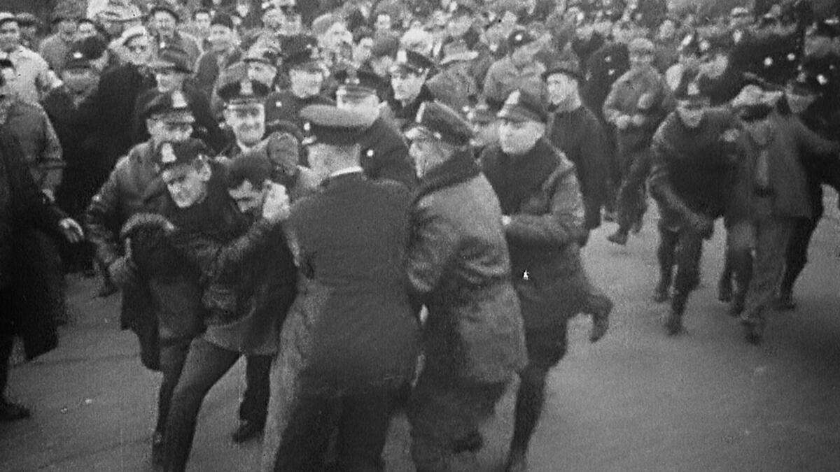 Police contain rioters in archival footage.