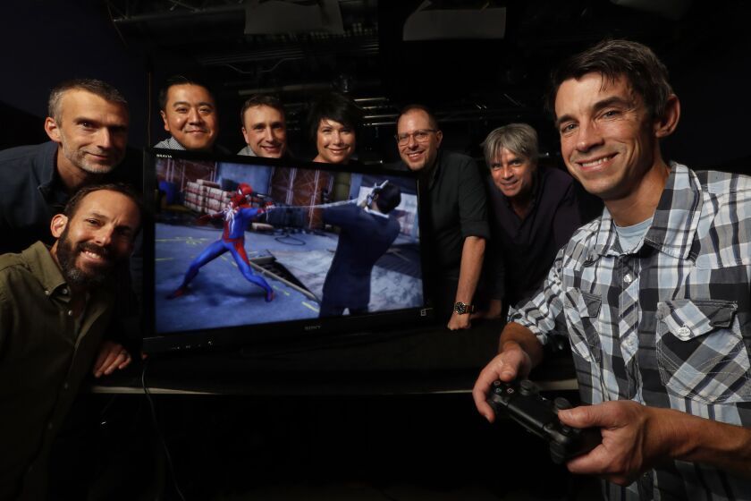 BURBANK, CA-JUNE 8, 2018: Ted Price, right, CEO/Founder of independant video game developer Insomniac Games, is photographed with members of his team, clockwise from lower left-Ryan Schneider, Chief Brand Officer, Al Hastings, Chief Architect, Jen Huang, Chief Financial Officer, Brian Hastings, Chief Creative Stratigist, Carrie Dieterle, Chief People Officer, Chad Dezern, Chief Creative Officer, and John Fiorito, Chief Operating Officer, at their headquarters in Burbank. Image on the screen is from Marvel's Spider-Man, a new video game they developed, which comes out on September 7, 2018. The company started in 1994 and has developed a total of 31 games spanning 17 franchises. (Mel Melcon/Los Angeles Times)