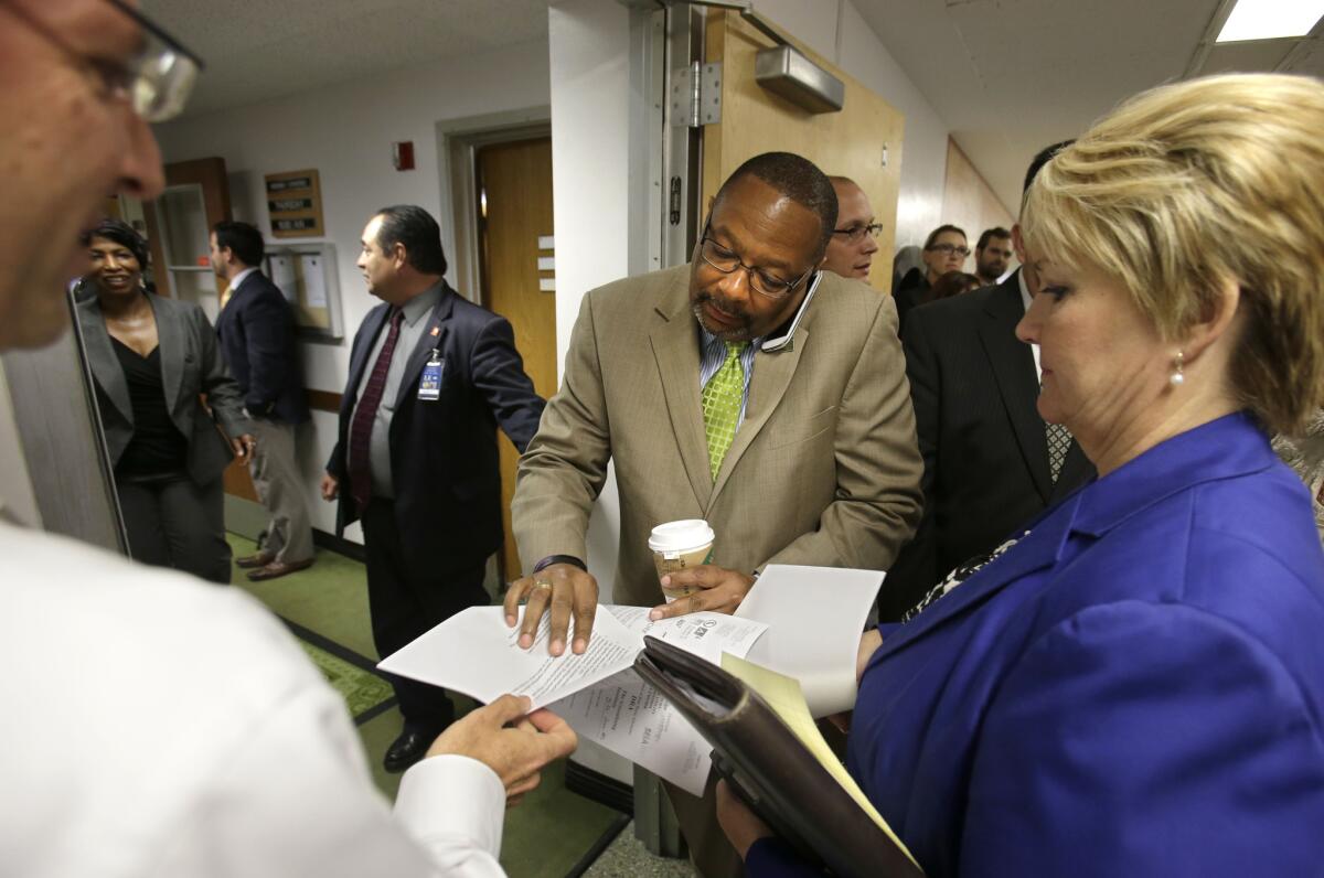 Lobbyists hand Assemblyman Reginald Jones-Sawyer, D-Los Angeles, center, information about legislation they are concerned about as he enters the Assembly chambers at the Capitol in Sacramento, Calif., Thursday, Sept. 12, 2013. Lobbyist and advocates are working the halls to try to sway lawmakers votes about bills before the Legislature. (AP Photo/Rich Pedroncelli) ** Usable by LA and DC Only **