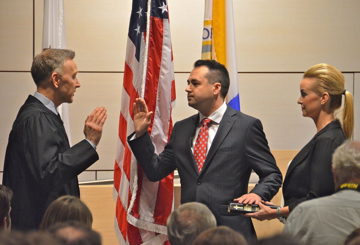 Judge James E. Rogan swears in Kevin Muldoon during Tuesday's Newport Beach City Council meeting.
