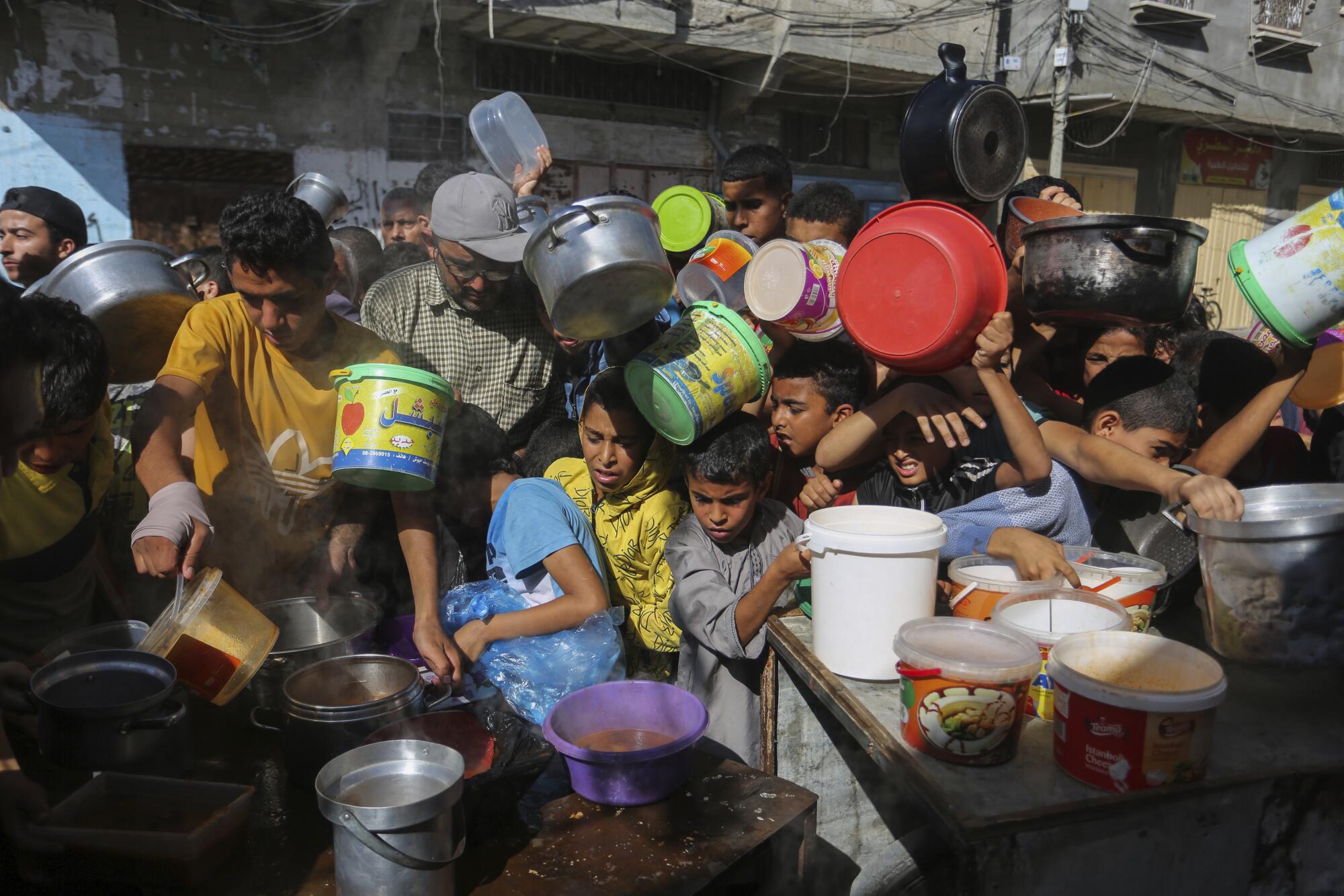 Palestinians crowding together as they wait for food distribution in south Gaza