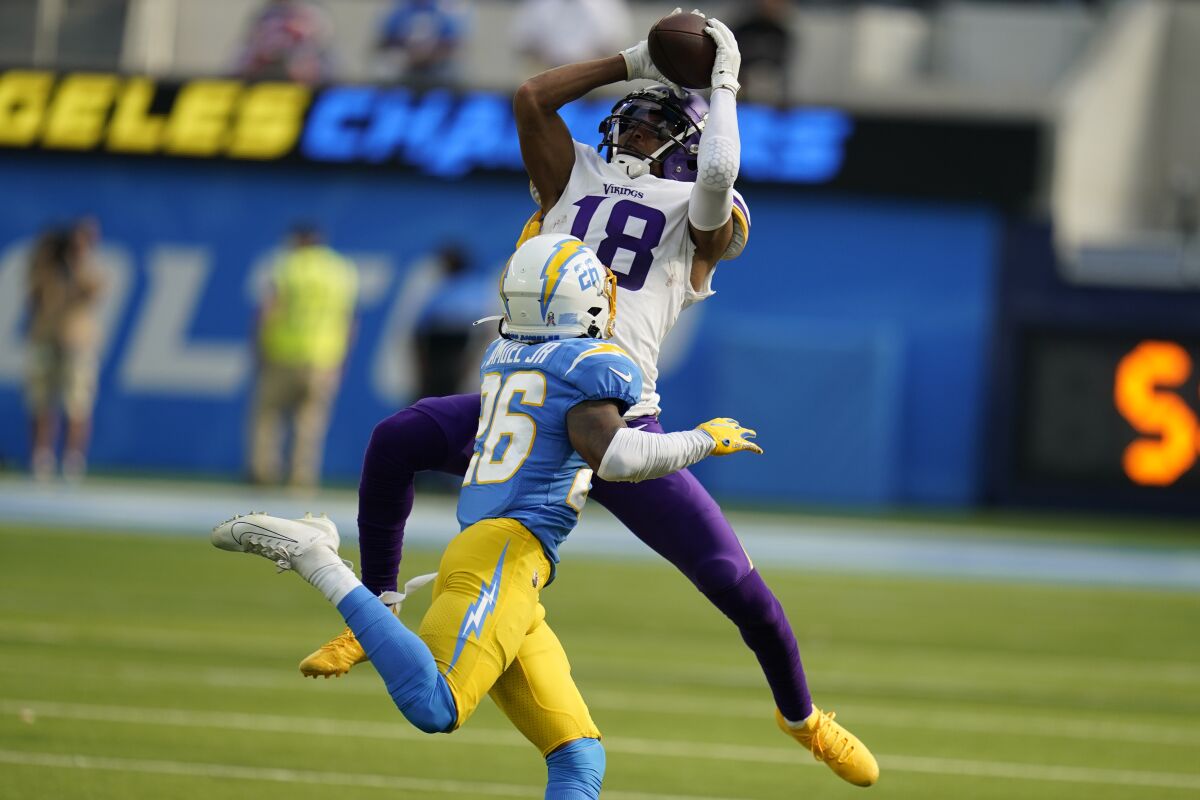 Los Angeles Chargers cornerback Asante Samuel Jr. (26) is charged with offensive holding on an incomplete pass to Minnesota Vikings wide receiver Justin Jefferson (18) during the first half of an NFL football game Sunday, Nov. 14, 2021, in Inglewood, Calif. (AP Photo/Gregory Bull)