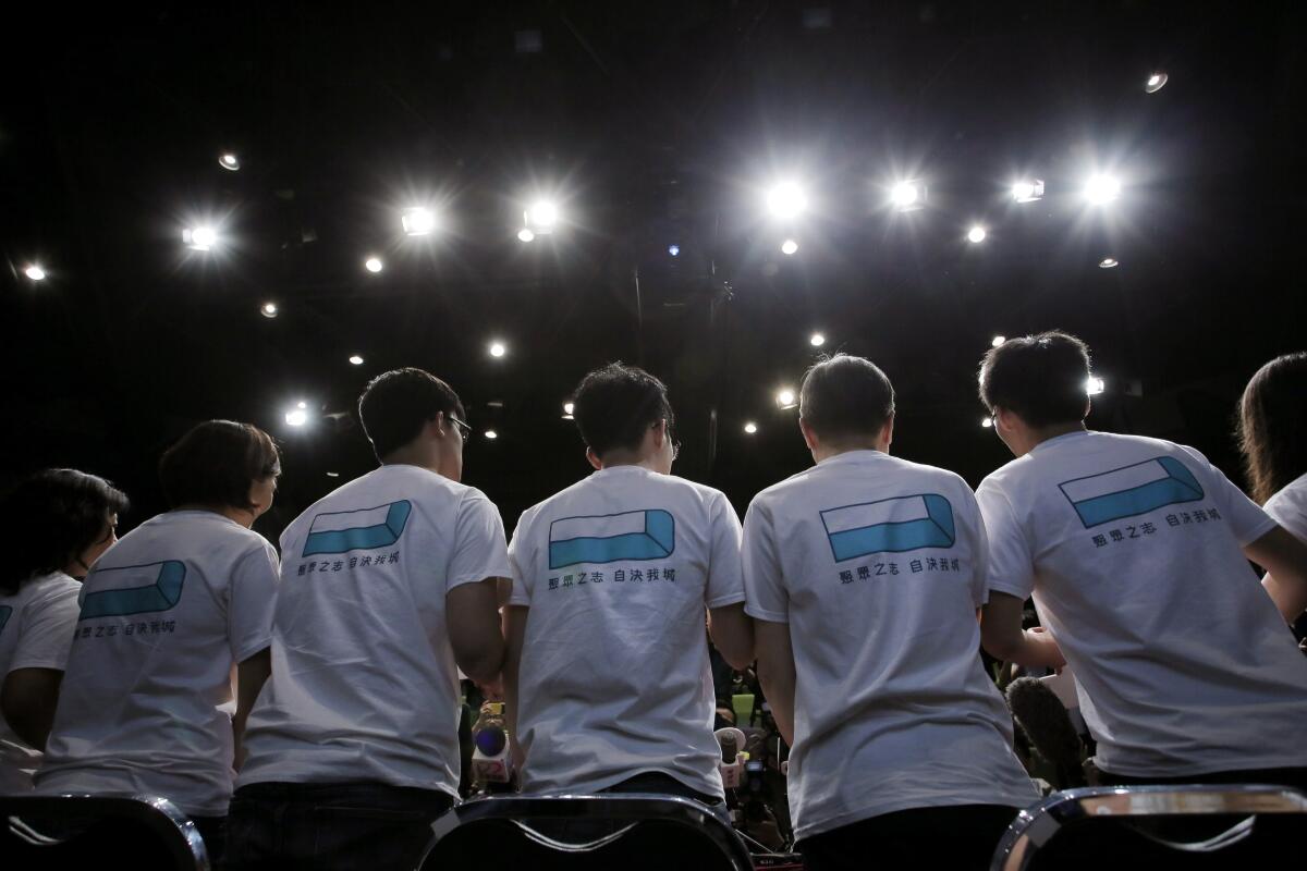 Men wearing matching T-shirts stand in a line as seen from behind