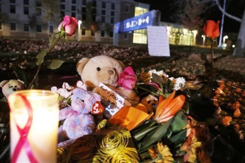 Candles and teddy bears are placed at Danvers High School prior to a candlelight vigil to mourn the death of Colleen Ritzer, a 24-year-old math teacher at Danvers High School on Wednesday, Oct 23, 2013, in Danvers, Mass. Ritzer was found slain in woods behind the high school, and Danvers High School student Philip Chism, 14, who was found walking along a state highway overnight was charged with killing her. (AP Photo/ Bizuayehu Tesfaye)