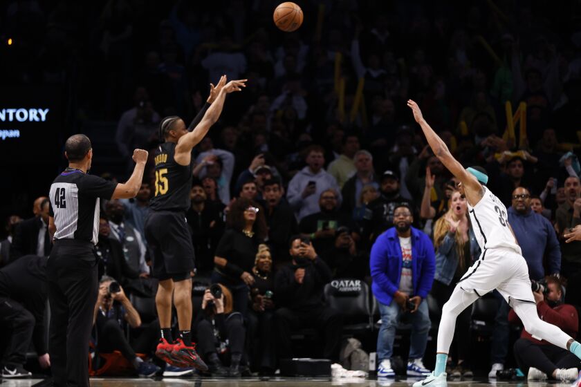 El alero de los Cavaliers de Cleveland Isaac Okoro anota el triple de la victoria frente el pívot de los Nets de Brooklyn Nic Claxton en el encuentro del jueves 23 de marzo del 2023. (AP Foto/Noah K. Murray)