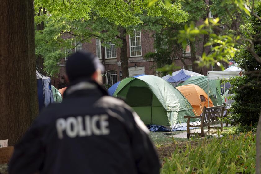 George Washington University police officer scan the area as students demonstrate on campus during a pro-Palestinian protest over the Israel-Hamas war on Friday, April 26, 2024, in Washington. (AP Photo/Jose Luis Magana)