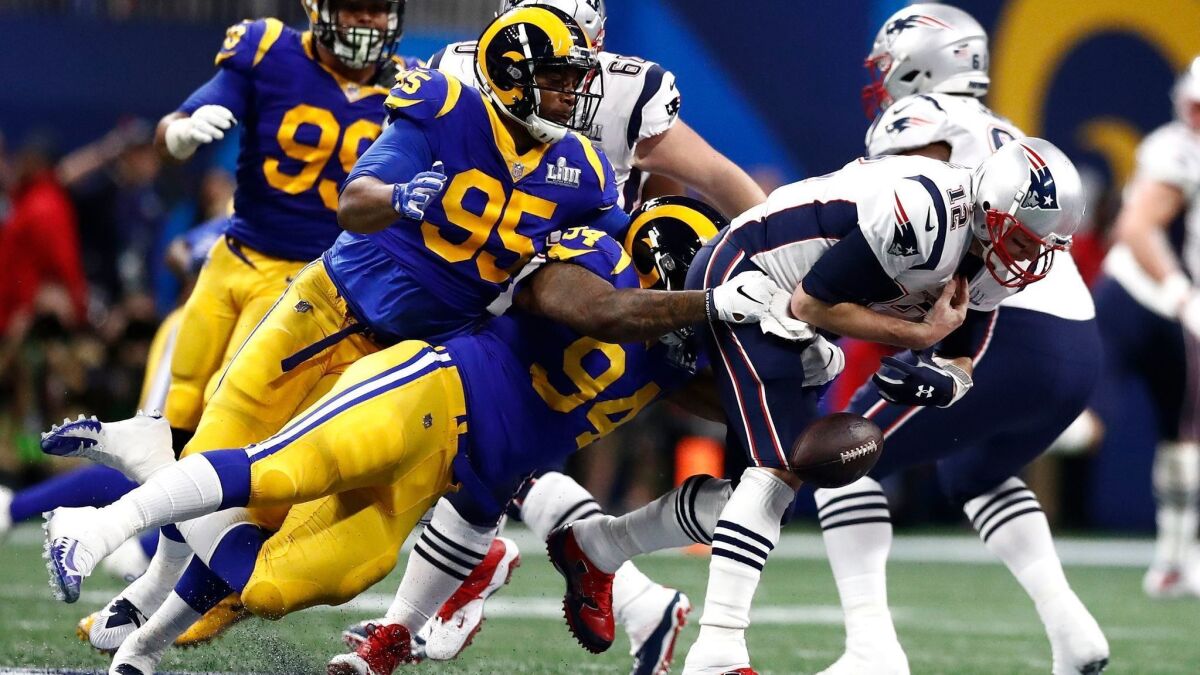 Patriots quarterback Tom Brady fumbles the ball on a tackle by Rams defensive end John Franklin-Myers during the first half.