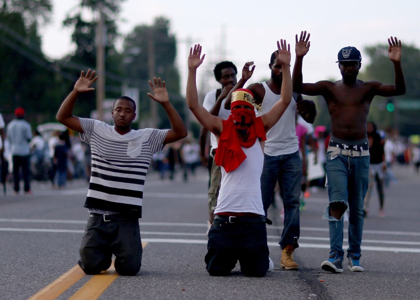 Demonstrators on Sunday raise their hands during a protest over the police shooting death of Michael Brown, who was unarmed.