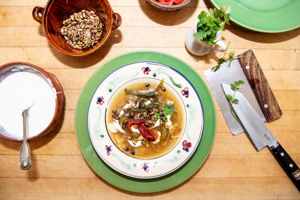 Sally Schmitt's famous tomatillo tortilla soup on a table with condiments.