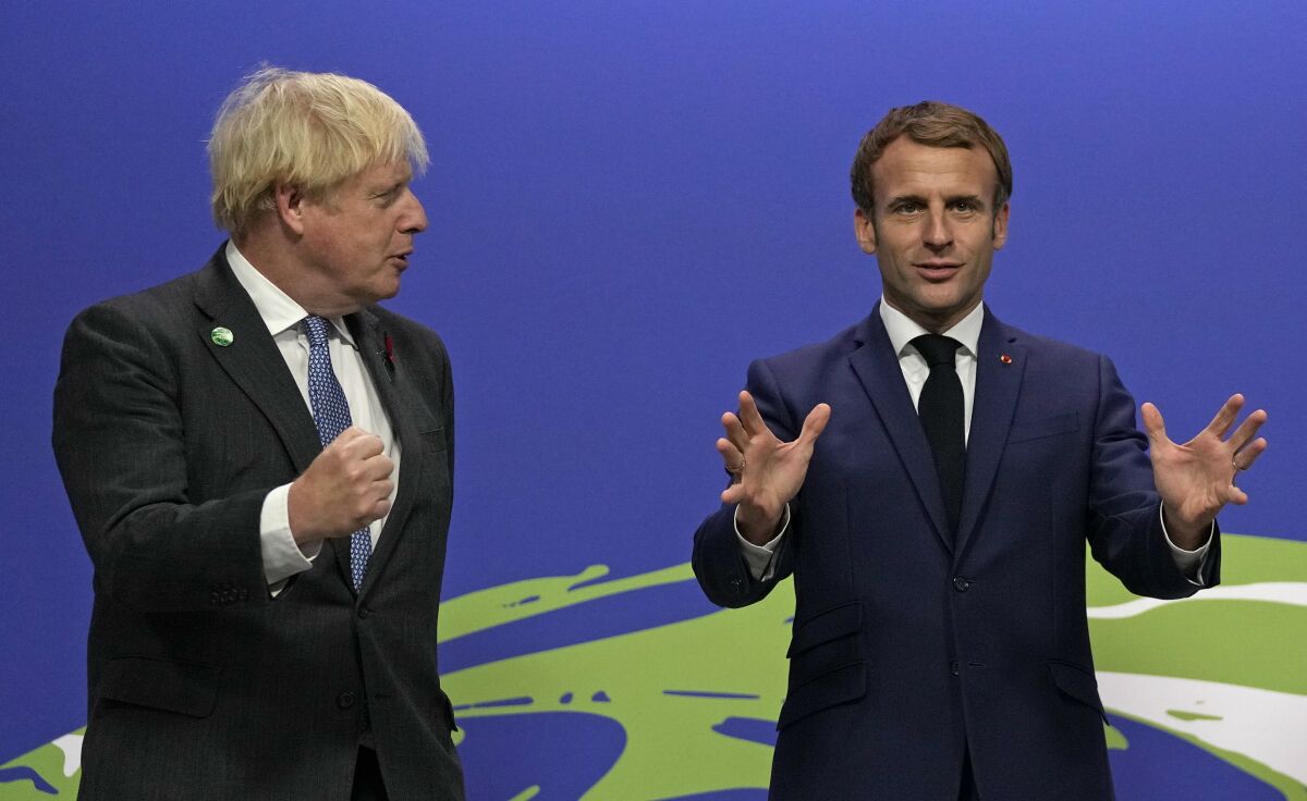 FILE - British Prime Minister Boris Johnson, left, greets French President Emmanuel Macron as he arrives at the COP26 U.N. Climate Summit in Glasgow, Scotland, Monday, Nov. 1, 2021. France has threatened to bar British boats from some of its ports and tighten checks on boats and trucks carrying British goods if more French vessels aren't licensed to fish in U.K. waters by Tuesday. (AP Photo/Alastair Grant, File)