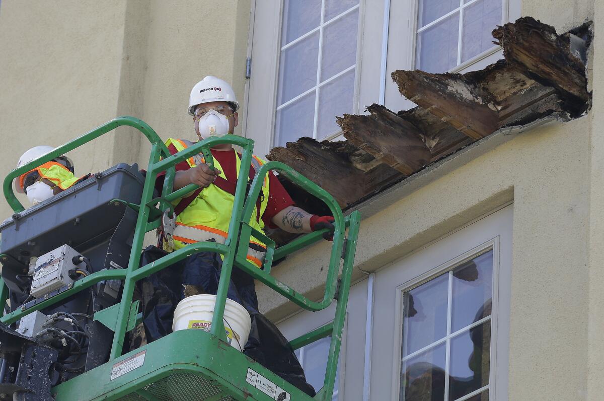 A crew works on the remaining wood of an apartment building balcony that collapsed in Berkeley on June 18, two days after the fatal incident. The Alameda County district attorney promised a thorough investigation.