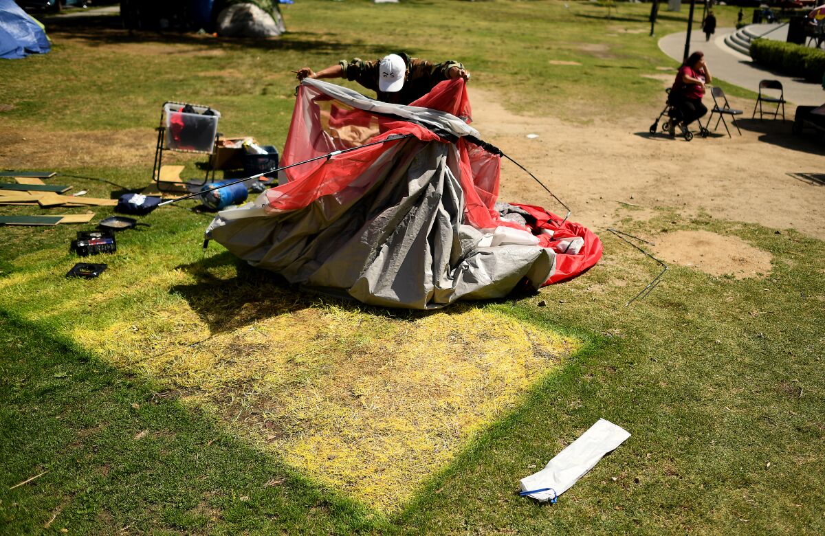 A homeless man tears down his tent