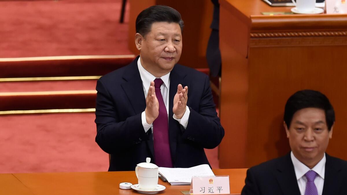Chinese President Xi Jinping applauds during the opening session of the National People's Congress, China's legislature, at the Great Hall of the People in Beijing on March 5, 2018.