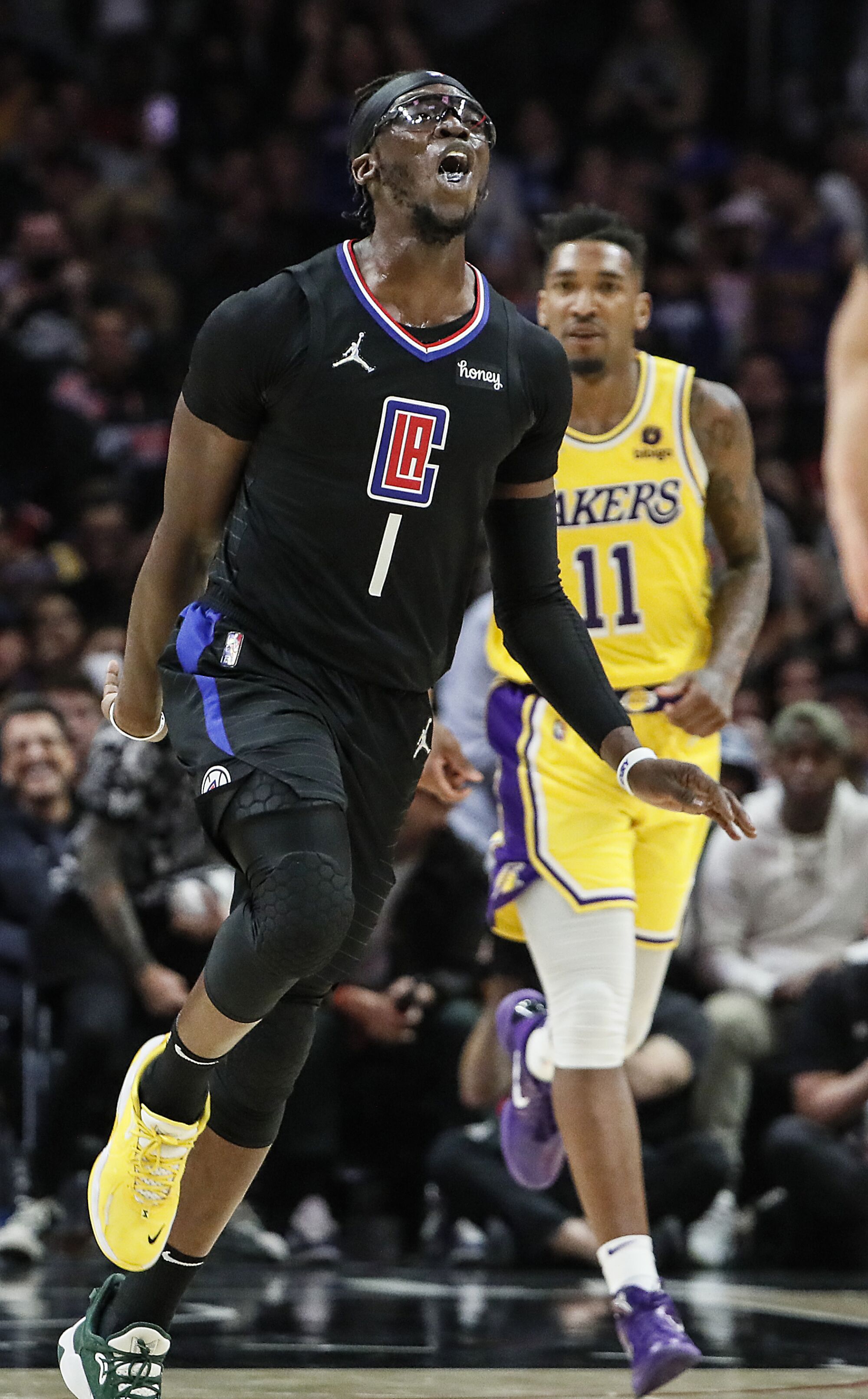 Clippers guard Reggie Jackson encourages fans to cheer as he leads the Clippers to a 132-111 win over the Lakers.