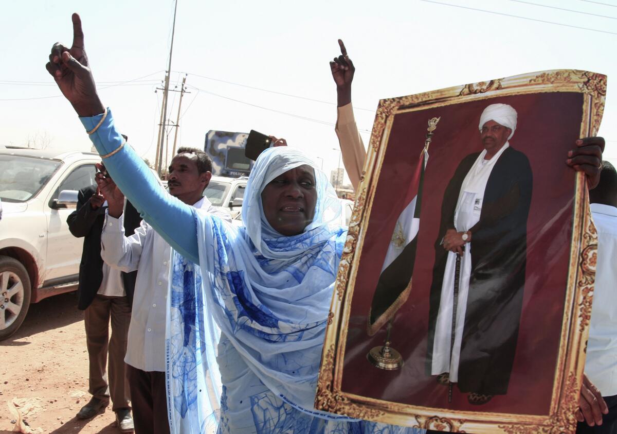Una partidaria del derrocado presidente de Sudán, Omar Bashir, hace gestos durante una manifestación ante un tribunal de la capital, Jartum, durante su juicio.