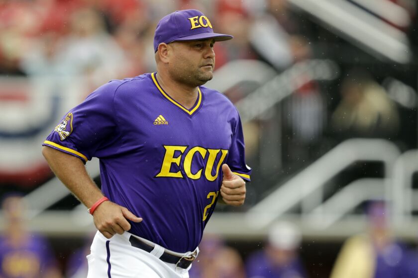 FILE - In this June 7, 2019, file photo, East Carolina head coach Cliff Godwin runs to question a call during the fourth inning in Game 1 of an NCAA college baseball super regional tournament game against Louisville, in Louisville, Ky. The Pirates are in the field for the seventh time in coach Cliff Godwin's eight seasons. (AP Photo/Darron Cummings, File)