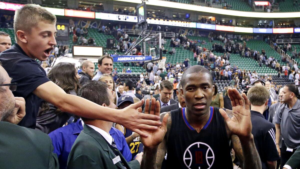 A fan high-fives Clippers guard Jamal Crawford, who won the game against the Jazz with a last-second shot in overtime Friday.