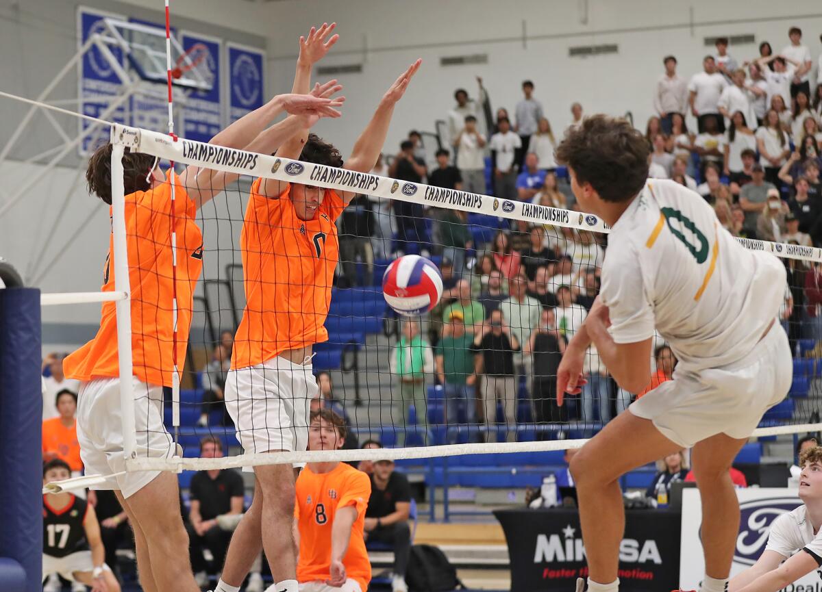 Huntington Beach's Kaegan Ramdhani (0) blocks a kill by Mira Costa's Thatcher Fahlbusch (0).