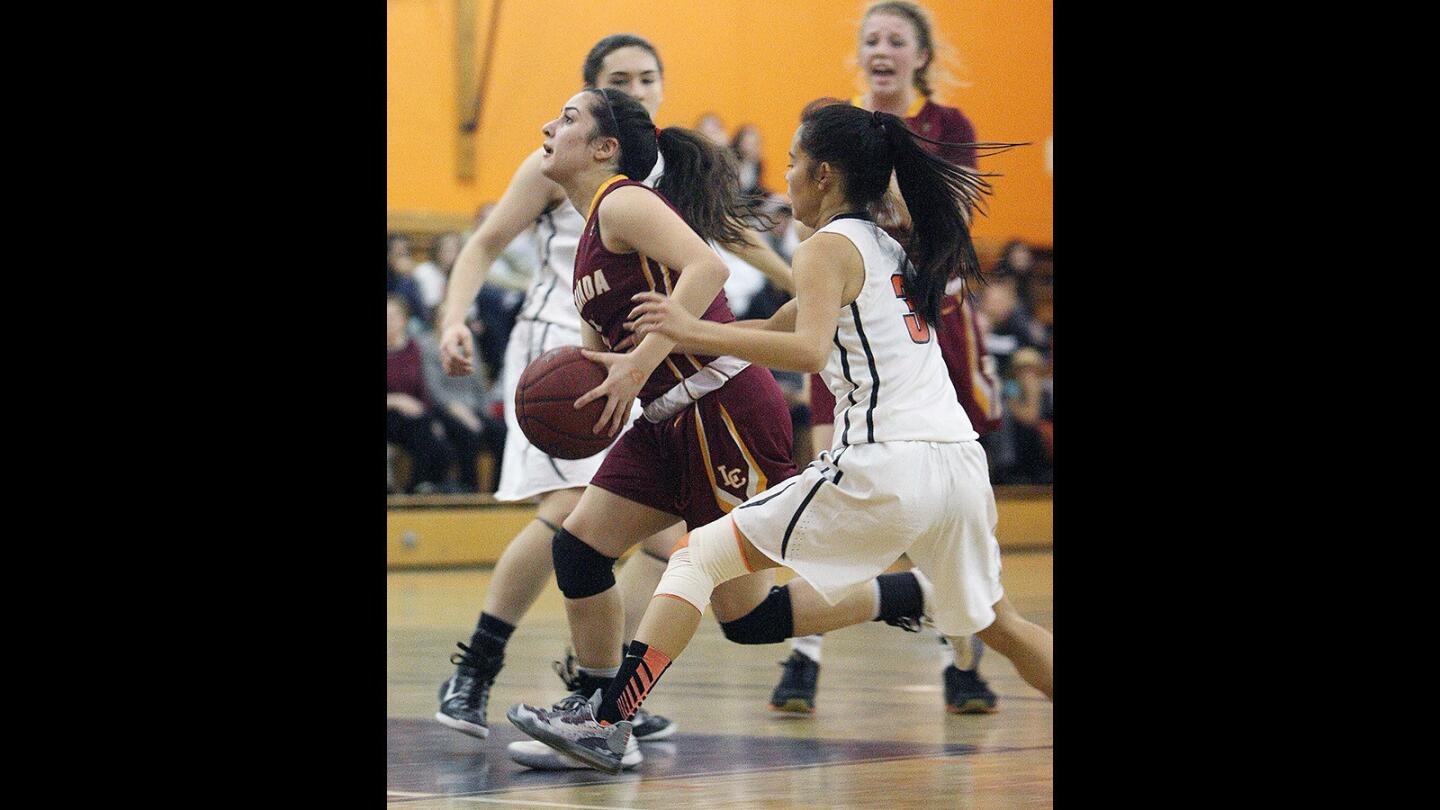 La Canada's Kristina Kurdoghlian goes up for a shot attempt between South Pasadena defenders Kayla Zhang and Jade Lin during a game on Friday, February 5, 2016.