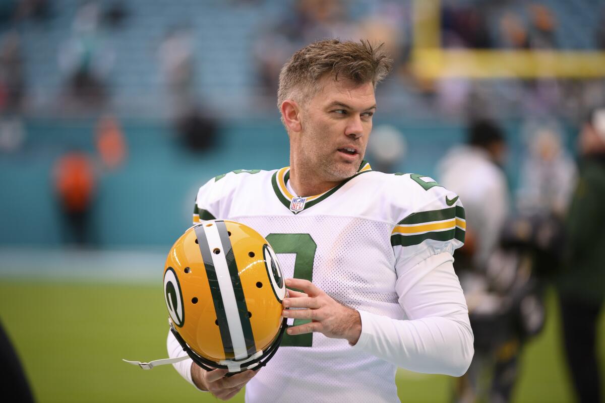 Mason Crosby holds his helmet on the field before an game against the Dolphins last season.