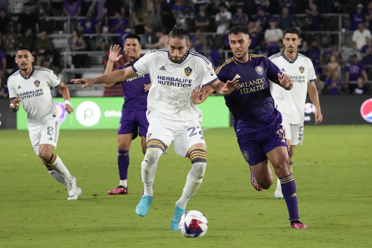 The Galaxy's Martín Cáceres, front left, gets in front of a pass intended for Orlando City's Martin Ojeda on April 29, 2023.
