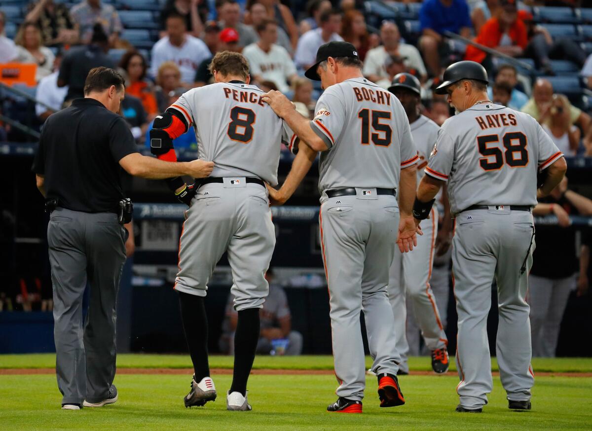 Giants outfielder Hunter Pence (8) is helped off the field by Manager Bruce Bochy (15) after injuring his leg while running to first base on June 1.
