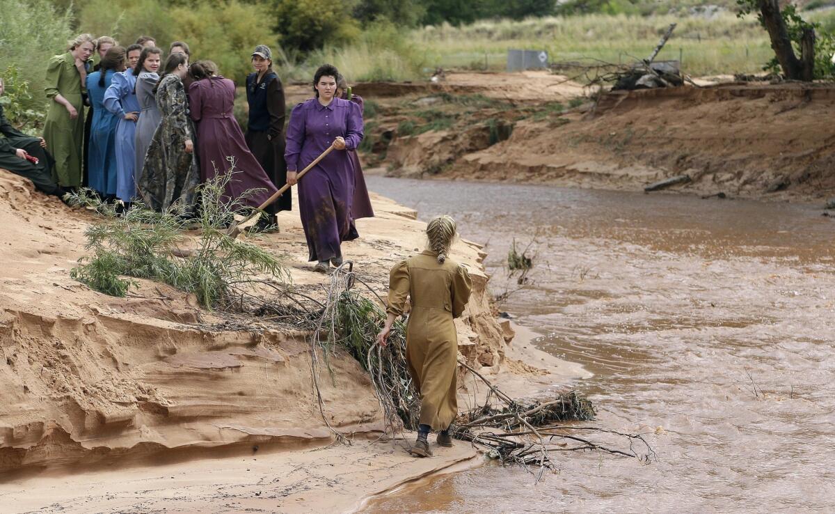 People search along a stream after a flash flood in Colorado City, Ariz.