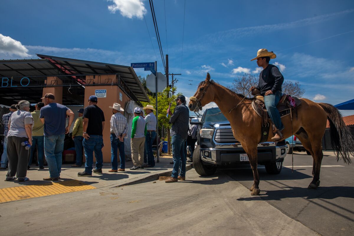 A person on horseback joins a town hall meeting.