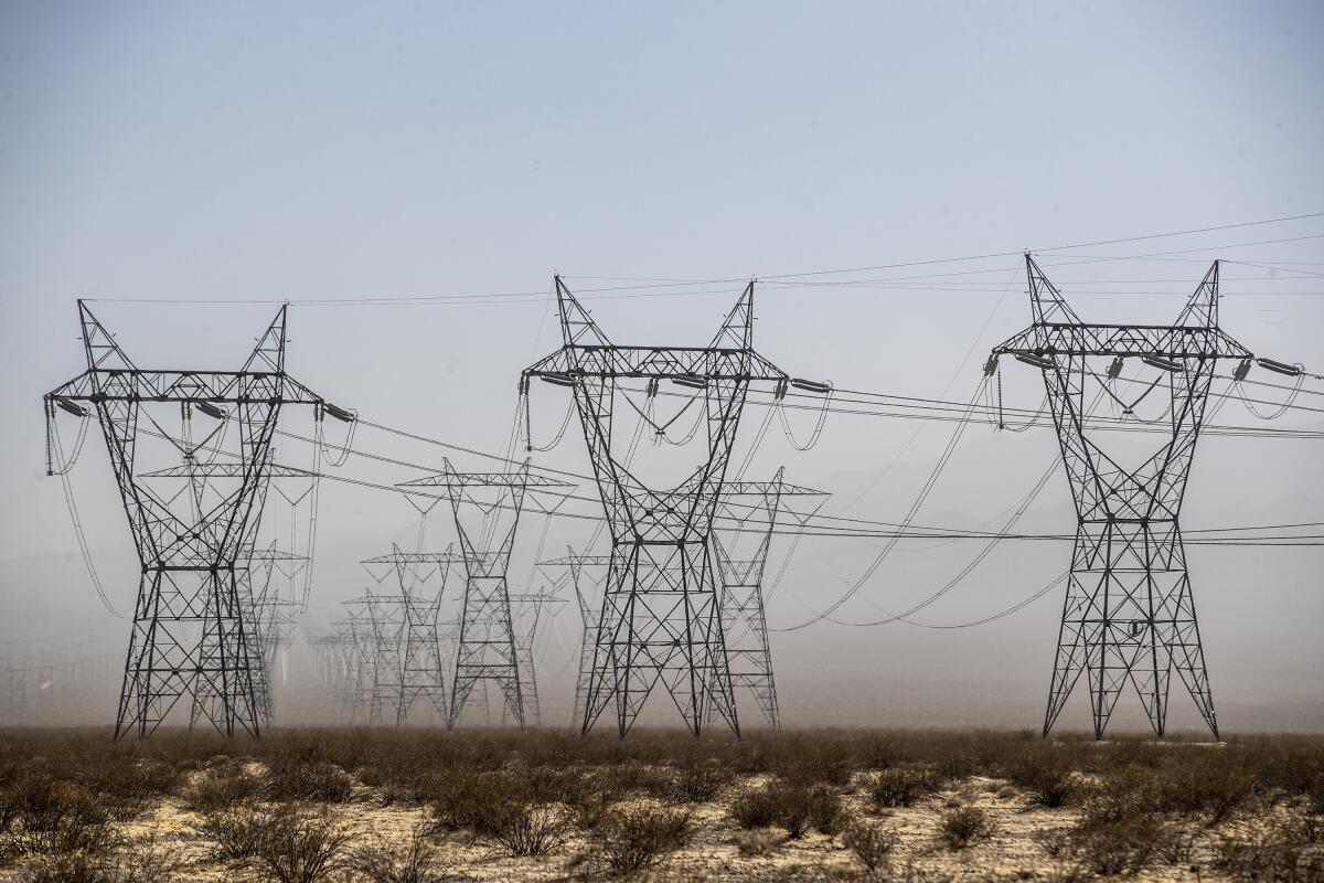 Transmission towers and power lines in a desert.