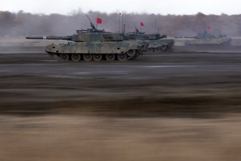 Japanese Ground-Self Defense Force (JGDDF) Type 90 tanks drive toward a target during the annual drill with live ammunitions exercise at Minami Eniwa Camp Monday, Dec. 6, 2021, in Eniwa, northern Japan of Hokkaido. Dozens of tanks are rolling over the next two weeks on Hokkaido, a main military stronghold for a country with perhaps the world's most little known yet powerful army. (AP Photo/Eugene Hoshiko)