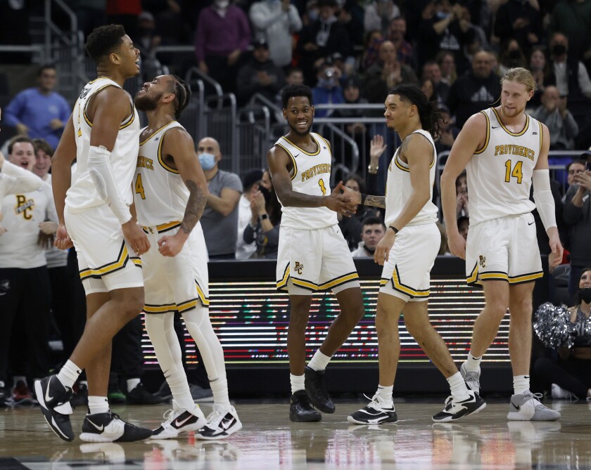 Providence players Ed Croswell, left, Jared Bynum (4), Al Durham (1), Alyn Breed, second right, and Noah Horchler (14) celebrate as they extend their lead late during the second half of an NCAA college basketball game against Butler, Sunday, Jan. 23, 2022, in Providence, R.I. (AP Photo/Mary Schwalm)