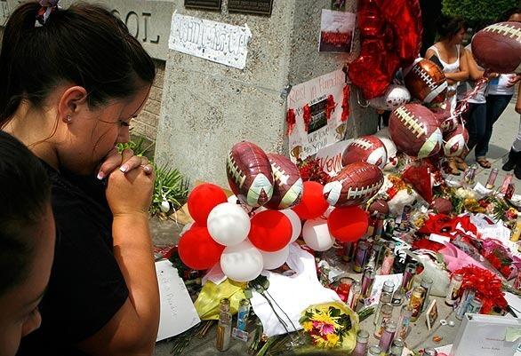 Students at Garden Grove High School gather in front of the school around a memorial for fellow student Kevin Telles. Telles, 17, collapsed and died Friday night during a football game against Westminster High. The cause of death remains unresolved.