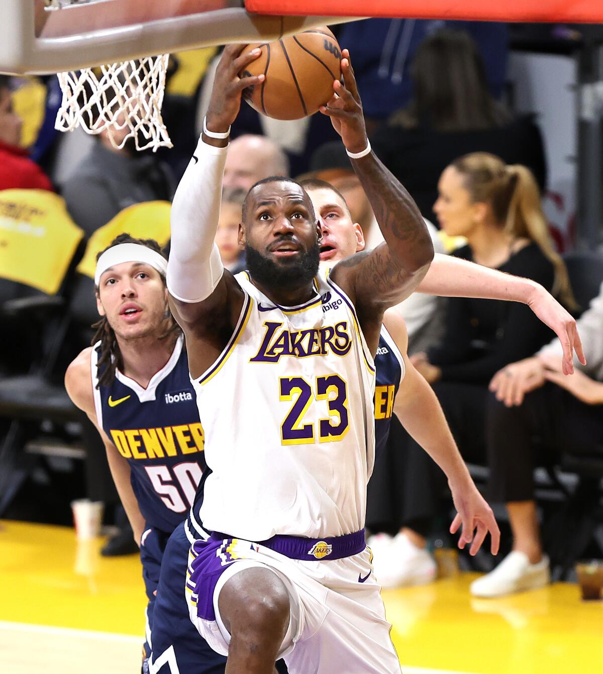 Lakers star LeBron James drives past Denver's Aaron Gordon, left, and Nikola Jokic.
