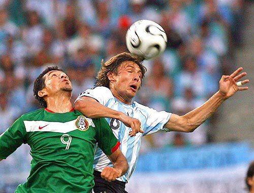 Jared Borgetti of Mexico (L) vies with Gabriel Heinze of Argentina for the ball.