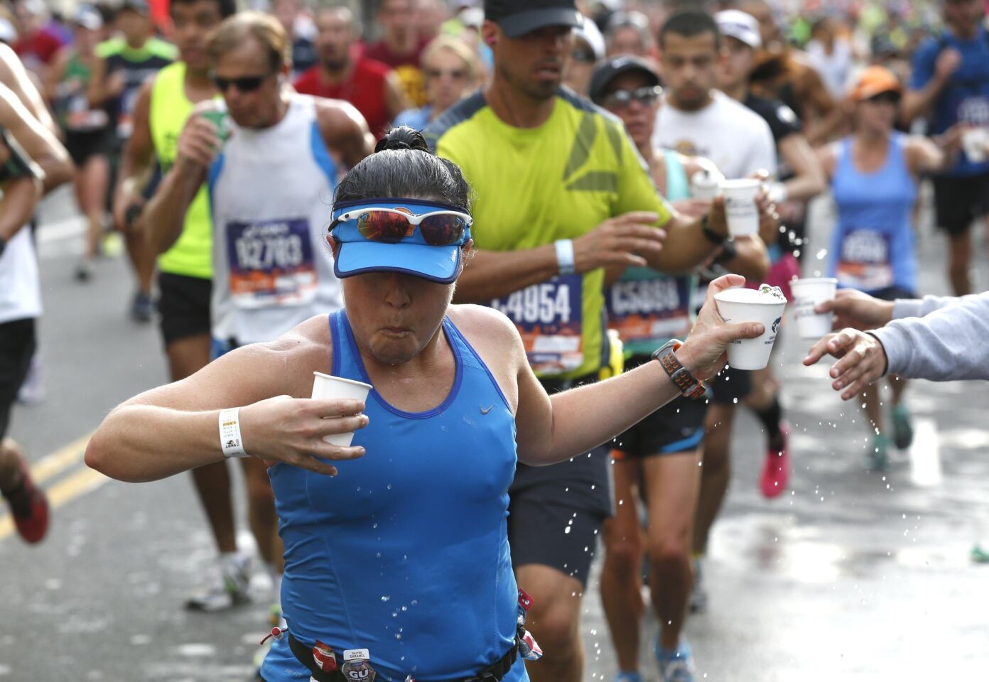 Runners grab water along Hollywood Blvd. during the 30th Los Angeles Marathon.